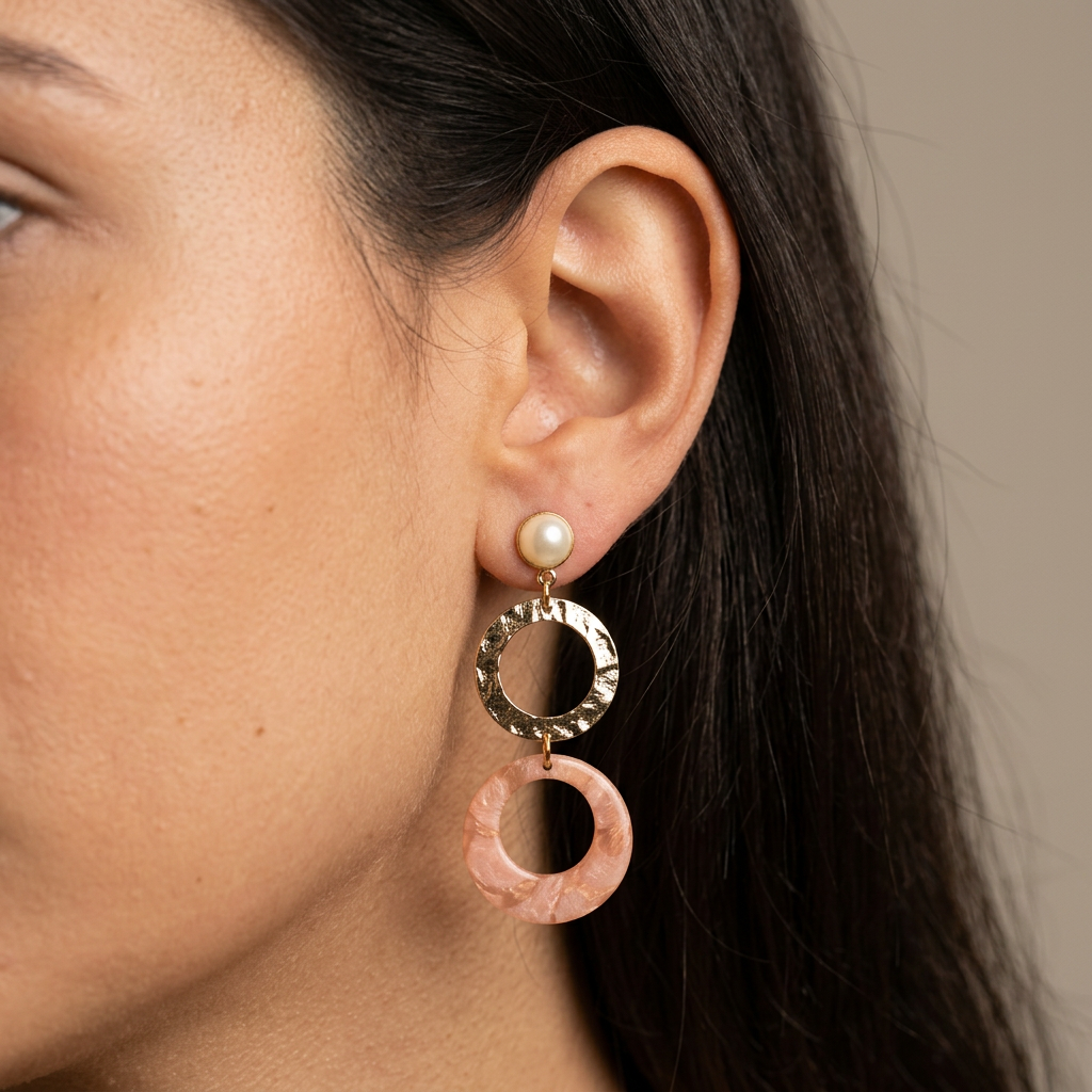 Boucles d'oreilles doubles cercles Nāca rose et bronze portées à l'oreille, bijou pendant fait main en France